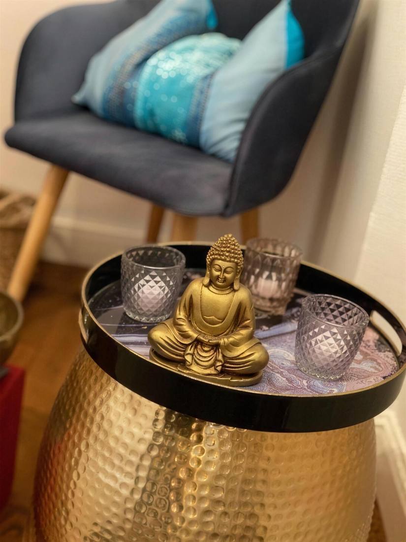 Buddha-Figur und Klangschalen auf einem Beistelltisch